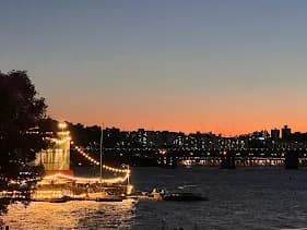 Sunset over the river with a lit boat